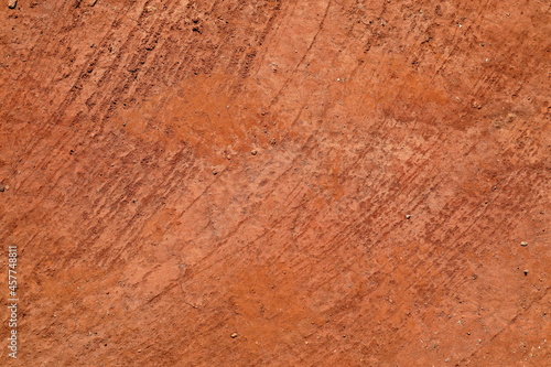 Abstract natural background from texture of orange red terracota clay soil. Rustic abstract background. Earthy colours. Concept of background, abstract, texture, natural tones, Africa. photo