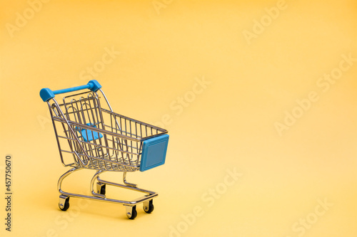 Shopping cart on a yellow background. Black friday gift sales. Copy space