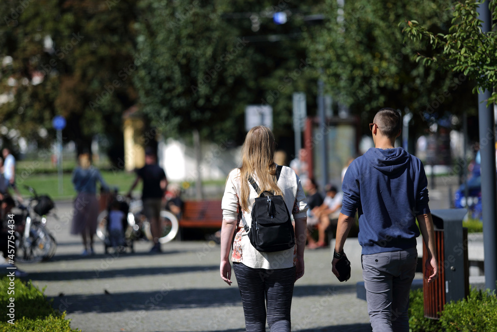 Para młodych ludzie wypoczywają, spacerują na deptaku, we Wrocławiu. - obrazy, fototapety, plakaty 