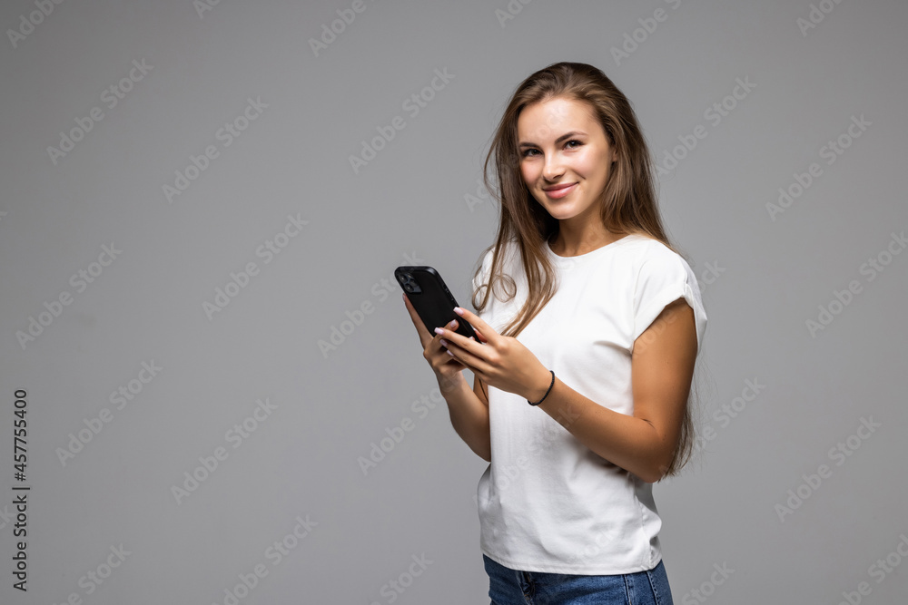 Happy woman using smartphone over gray background Happy woman using smartphone over gray background