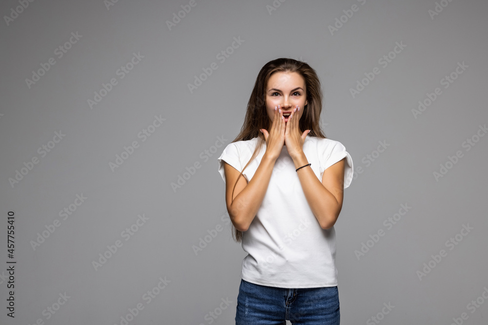 Pretty young woman covering her mouth over grey background Pretty young woman covering her mouth over grey background