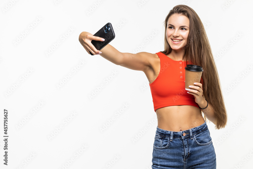 Beautiful young woman is making selfie with smartphone on white background Beautiful young woman is making selfie with smartphone on white background