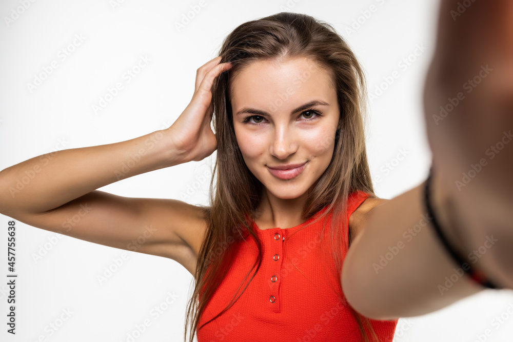 Beautiful young woman is making selfie with smartphone on white background Beautiful young woman is making selfie with smartphone on white background