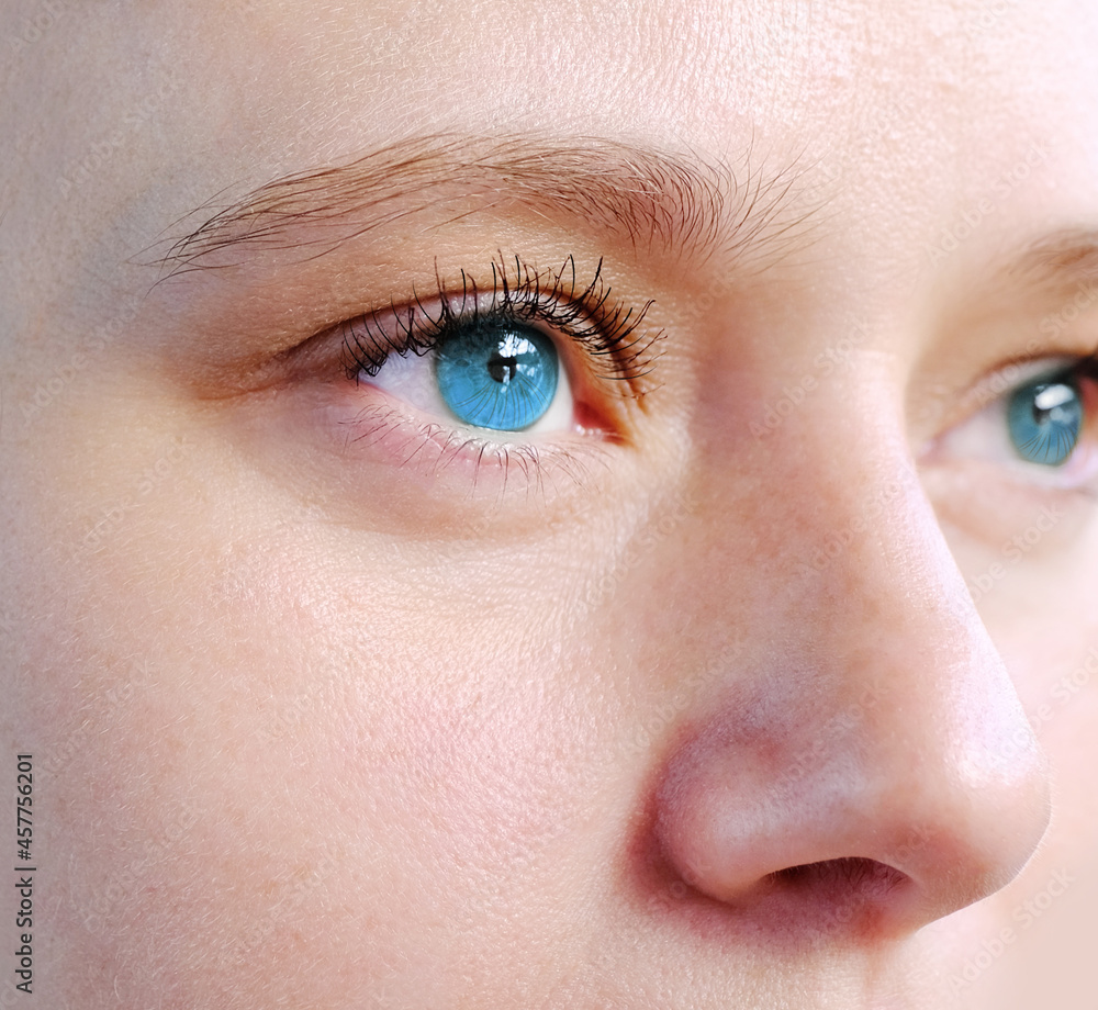 Obraz premium close up part of the woman's face, girl 20-29 years old, human eye looking to the side, the concept of surveillance, peeping, tracking, vision examination, cosmetic procedures