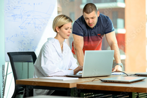 Two office workers. Teacher and student. Two people working together. Mobbing at the workplace. Explanation situation. Teaching using technologies. Learning online. Mentoring colleagues.