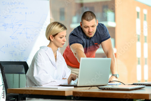 Two office workers. Teacher and student. Two people working together. Mobbing at the workplace. Explanation situation. Teaching using technologies. Learning online. Mentoring colleagues.