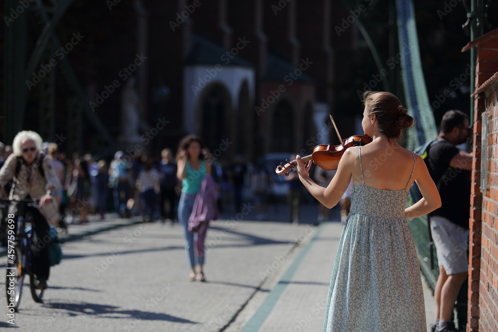 Piękna moda dziewczyna, skrzypaczka gra na skrzypcach na moście we Wrocławiu. - obrazy, fototapety, plakaty 