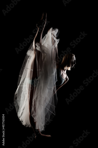 Fototapeta Naklejka Na Ścianę i Meble -  ballerina with a white dress and black top posing on black background
