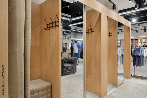 Row of empty fitting rooms with fabric curtains in a men's clothing store