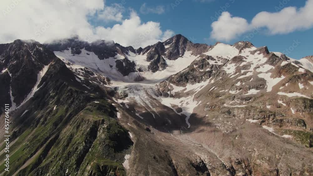 Steep rocky mountains with cliffs and ledges, covered with snow and clouds Steep rocky mountains with cliffs and ledges, covered with snow and clouds