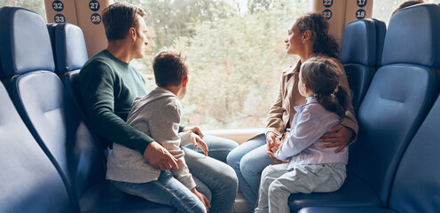 Family with two little kids enjoying train journey together