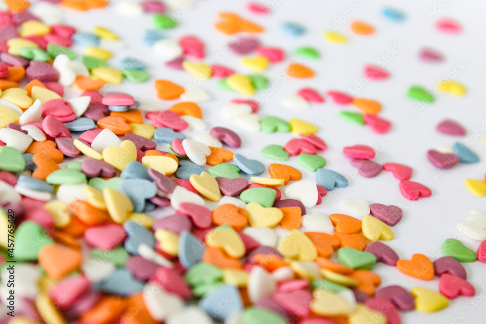 A contrasting spread of vivid heart candies against a crisp white surface, offering a blend of focus and blur, ideal for design backdrops. A contrasting spread of vivid heart candies against a crisp white surface, offering a blend of focus and blur, ideal for design backdrops.