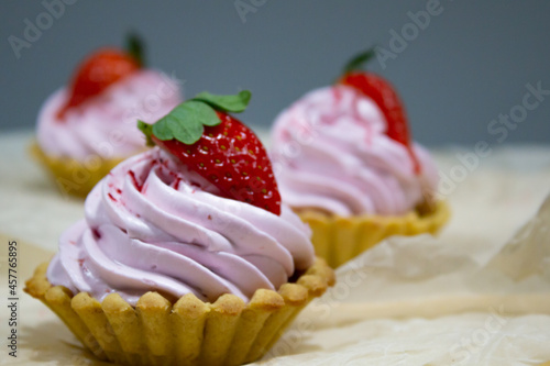 Delectable mini dessert tarts showcasing creamy swirls and a juicy strawberry, perfect for sweet indulgence moments.