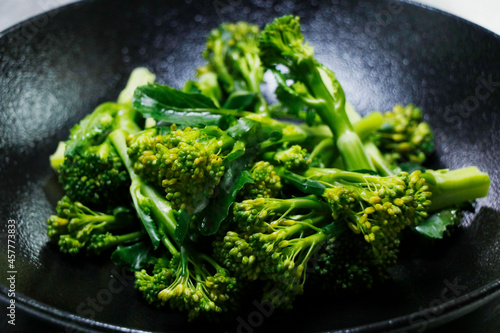 steam broccoli or broccolini with black background in close up, healthy food concept, vegetarian diet photo