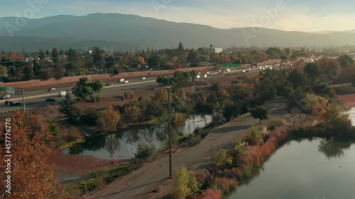 Aerial: Los Gatos Creek County Park and Freeway traffic. Campbell, Silicon Valley, California, USA