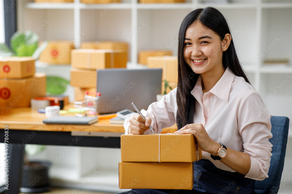 Portrait of Starting small businesses SME owners female entrepreneurs working on receipt box and check online orders to prepare to pack the boxes, sell to customers, sme business ideas online. Portrait of Starting small businesses SME owners female entrepreneurs working on receipt box and check online orders to prepare to pack the boxes, sell to customers, sme business ideas online.