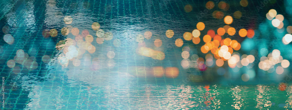 blur light of bar or pub reflection on blue water swimming pool summer party at night banner background blur light of bar or pub reflection on blue water swimming pool summer party at night banner background