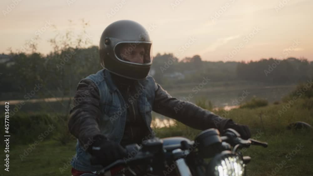 A biker wearing a helmet riding a motorcycle in the park A biker wearing a helmet riding a motorcycle in the park