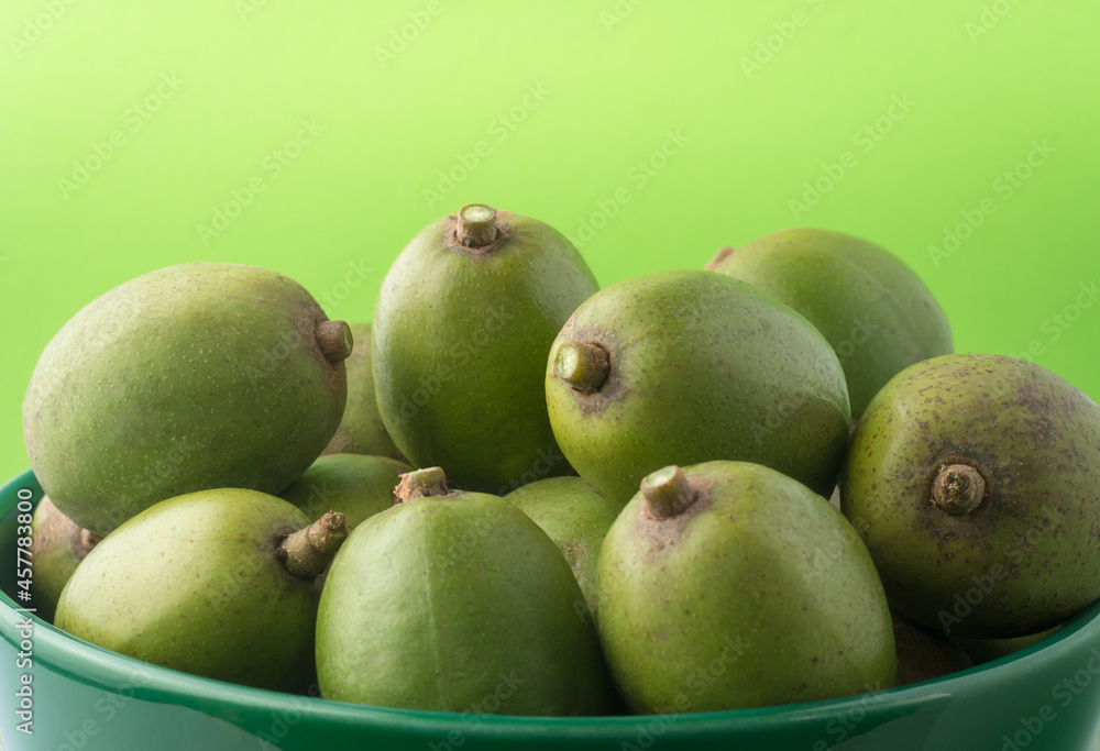 ambarella or june plum curry, edible fruit in a bowl, closeup view taken on a light green background ambarella or june plum curry, edible fruit in a bowl, closeup view taken on a light green background