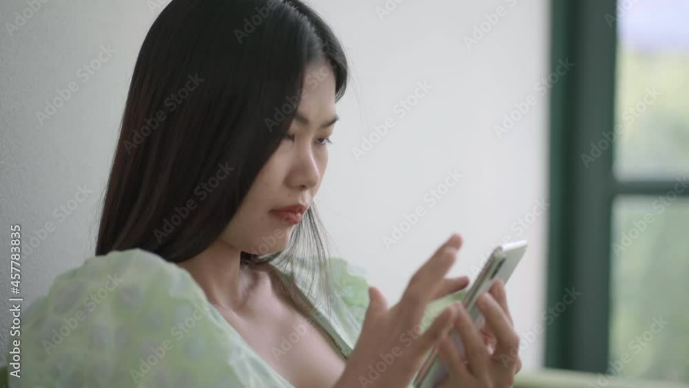 Beautiful asian women sitting on sofa in coffee shop use smartphone online communication internet of thing concept Beautiful asian women sitting on sofa in coffee shop use smartphone online communication internet of thing concept