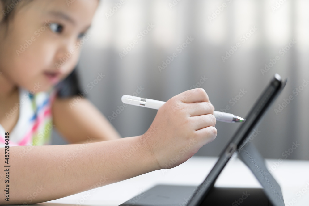 closeup hand of child study online or kid girl enjoy write or student art drawing learning on computer tablet screen by touch pen with doing homework or people back to school by learn from home on pad closeup hand of child study online or kid girl enjoy write or student art drawing learning on computer tablet screen by touch pen with doing homework or people back to school by learn from home on pad