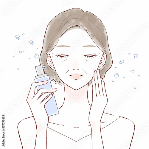 ミストタイプの化粧水を顔にふりかける中年女性