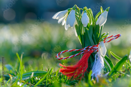 Martisor and snowdrops on wooden floor. 1st of March Romanian eastern european spring tradition to offer such gifts to loved ones. Martisoare, symbols of the beginning of spring photo