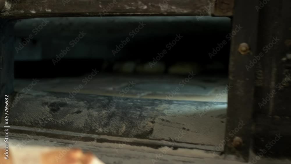 Shot of inside oven, baker’s peel going out with some crusty and goldy loaf bread Shot of inside oven, baker’s peel going out with some crusty and goldy loaf bread
