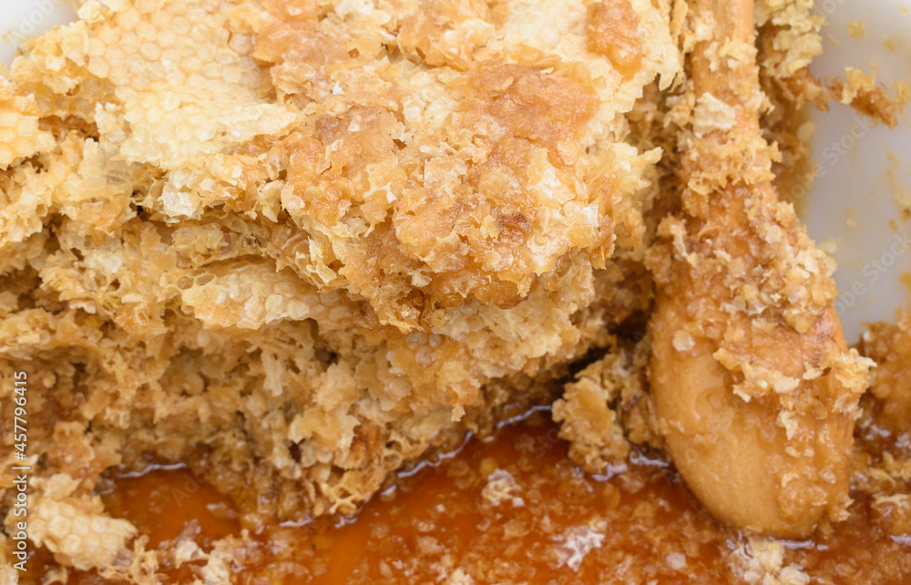 Broken honeycomb. Wooden spoon in thick honey. Sweet ingredient concept, dainty, wholesome food. Broken honeycomb. Wooden spoon in thick honey. Sweet ingredient concept, dainty, wholesome food.