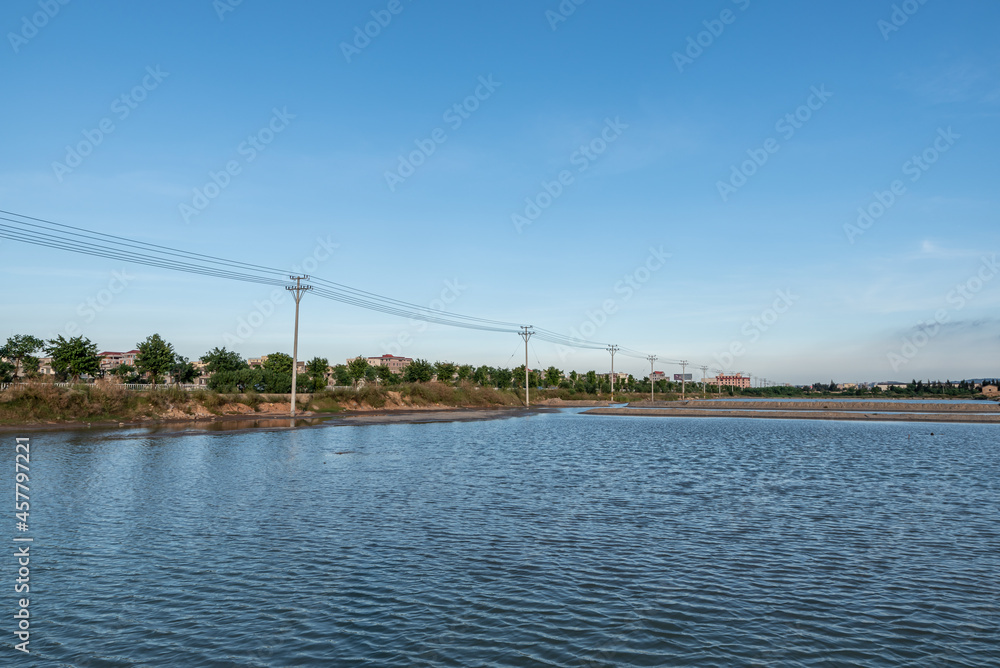 Fototapeta premium Aquaculture farms and saline alkali land by the sea under the blue sky