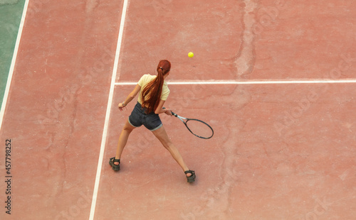 The girl plays tennis on the court. Sport