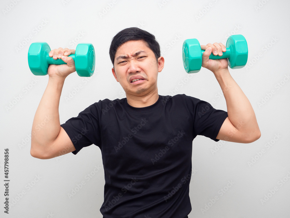 Asian man holding drumbbell feeling heavy for workout Asian man holding drumbbell feeling heavy for workout
