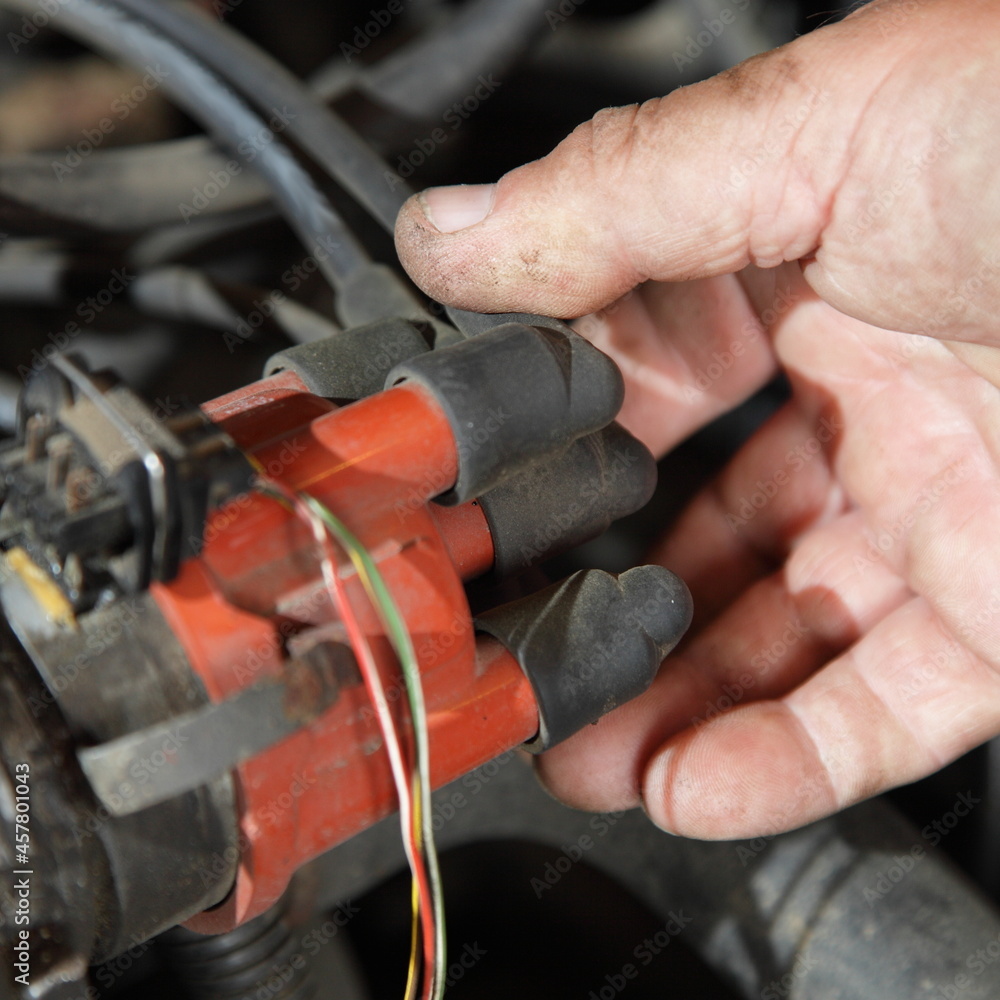 Car engine ignition system diagnostics, mechanic's hand holding