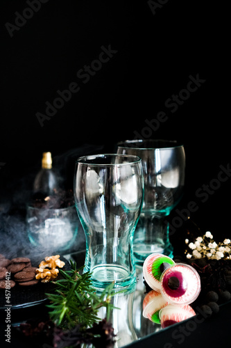 An eerie Halloween-themed cup, made of transparent glass, against a haunting black backdrop. Halloween glass cup.