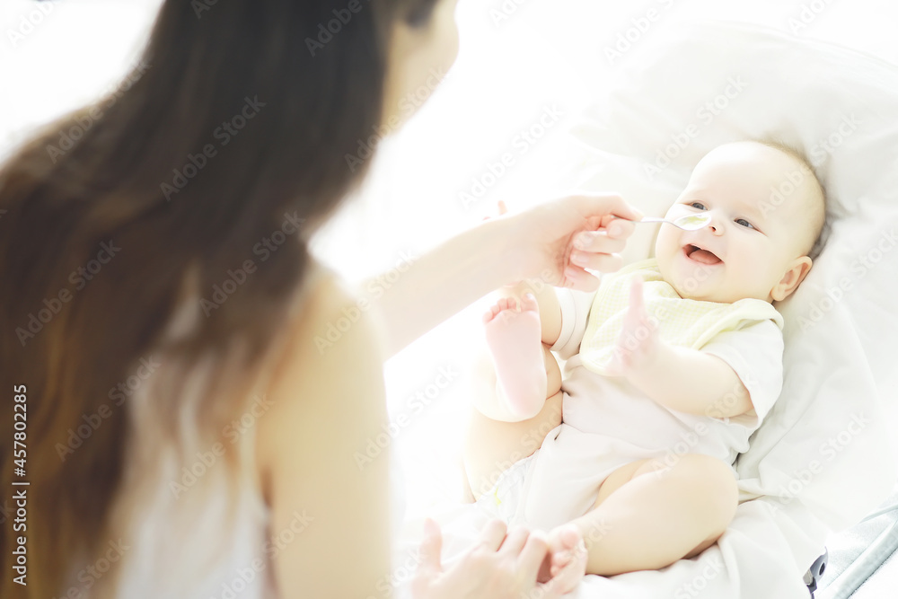 Maternity concept. A young mother feeds her little baby. First lure and breastfeeding. Family in white clothes. Maternity concept. A young mother feeds her little baby. First lure and breastfeeding. Family in white clothes.