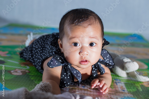 6 months old baby girl learning to crawl on the floor. Asian cute baby girl crawling on the floor with positive expression. 