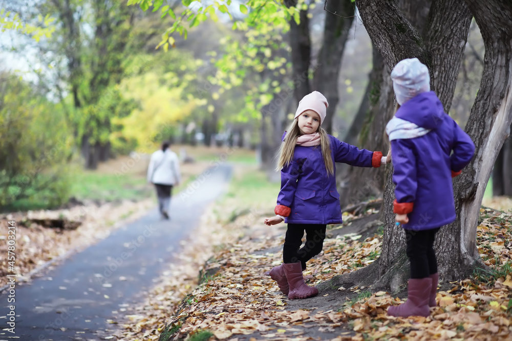Fototapeta premium Leaf fall in the park. Children for a walk in the autumn park. Family. Fall. Happiness.