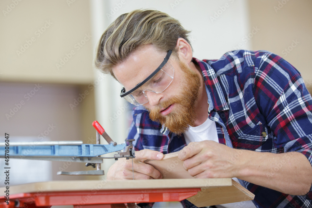 man using a machine to cut wood man using a machine to cut wood