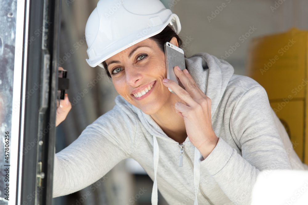 smiling female builder with telephone to her ear smiling female builder with telephone to her ear