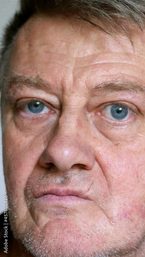 Senior man with gray hair takes off his glasses, massages the bridge of his nose and puts on his glasses again. Close-up portrait. Senior man with gray hair takes off his glasses, massages the bridge of his nose and puts on his glasses again. Close-up portrait.