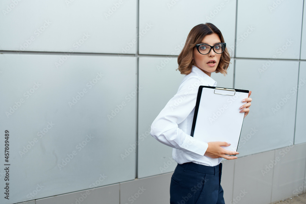 Business woman with documents in hands on the street near the building Business woman with documents in hands on the street near the building