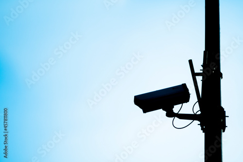 Silhouette of a CCTV camera with a blue background.