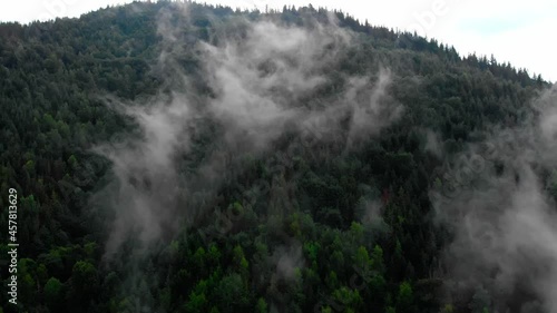 Amazing Aerial View. Flying over the high mountains in beautiful fog . Aerial camera shot. Air clouds. Fog. Steam.