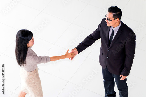 Business woman and her boss shaking hands during meeting at office.