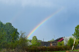 beautiful rainbow on blue sky in summer village. rural Russian landscape
