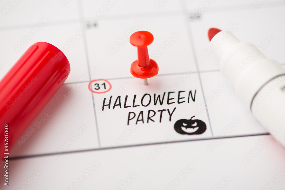Overhead photo of label date 31 october with inscription halloween party red pin marker and pumpkin isolated on the calendar background Overhead photo of label date 31 october with inscription halloween party red pin marker and pumpkin isolated on the calendar background