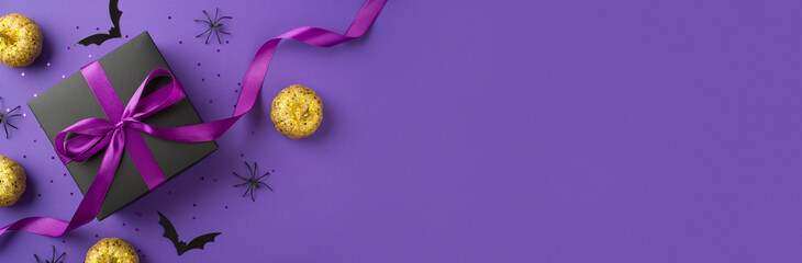 Top view photo of halloween decorations golden pumpkins bats spiders black giftbox with purple ribbon bow and confetti on isolated violet background with copyspace