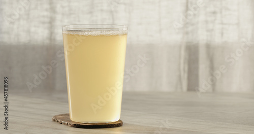 closeup ginger beer in a tumbler glass on oak table with copy space