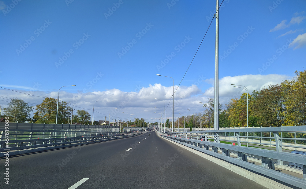 road with horizon on blue sky and clouds at daytime view from car.
