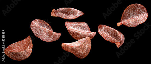 Falling salami slices isolated on black background photo